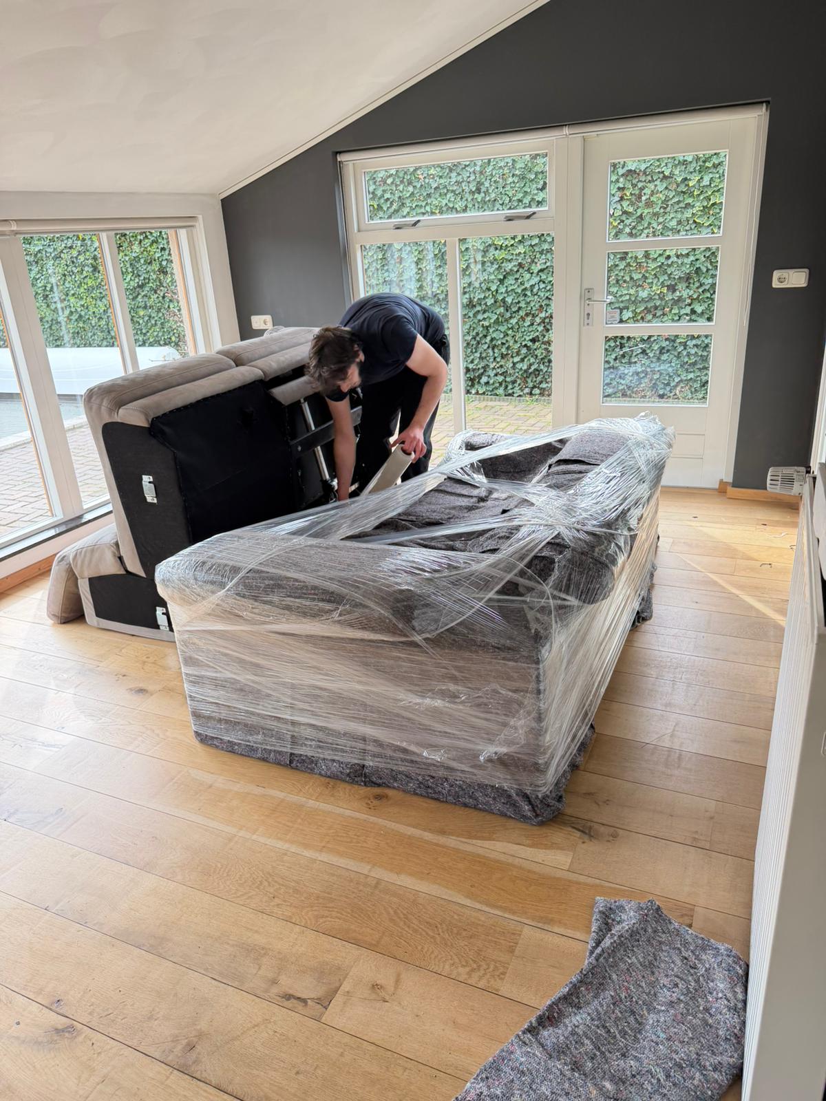 Verhuizer plaatst een bank in een woning